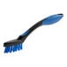 A close-up of a blue and black Lavex grout brush with a handle.