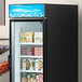 A blue Avantco sign panel above shelves in a refrigerator.