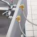 A Regency faucet with hoses attached to 90 degree elbows.