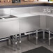 A Regency stainless steel underbar drainboard on a kitchen counter.