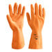 A close-up of a pair of large orange neoprene and latex gloves with a rubber palm.