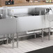 A Regency stainless steel underbar ice bin with bottle holders and a cold plate filled with ice.