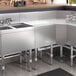 A Regency stainless steel underbar drainboard on a counter in a kitchen with a sink and counter.