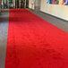 A red FloorEXP carpet runner on the floor with a white border.