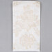 A white Hoffmaster Linen-Like guest towel with a white and brown floral pattern.