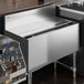 A Regency stainless steel sliding lid on an underbar ice bin.