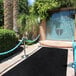 A black FloorEXP carpet runner with blue rope around it.
