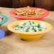 A tropical yellow Diamond Mardi Gras melamine bowl filled with green and white food.