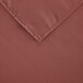 A close-up of a mauve rectangular cloth table cover on a table.