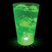 A 16 oz. plastic pint cup with a green LED light filled with a green drink.