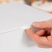 A person's hand opening a white customizable cake box.