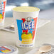 A close up of a ICEE Frosted Lemonade Freeze cup with a wooden spoon on a table.