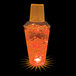 A close-up of a plastic shaker with orange LED lights and a drink inside.