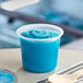 A plastic container of Luigi's Blue Raspberry Sorbet on a table.