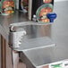 An Edlund commercial can opener with a blue handle on a metal surface.