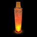 A close up of a 32 oz. plastic shaker cup filled with glowing orange liquid.