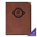 A brown leather H. Risch, Inc. menu cover on a table.