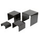 A group of black acrylic display risers on a table.