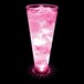 A 16 oz. customizable plastic pilsner cup with pink liquid and ice.