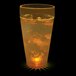 A 20 oz. plastic cup with ice and yellow LED light glowing in liquid.