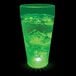 A 20 oz. customizable plastic cup with a green LED light glowing over a green drink.