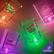 A group of customizable plastic square shot cups with pink LED lights on a table.
