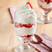 A glass of strawberries with Violife vegan whipped cream on top.