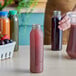 A person holding a round clear rPET juice bottle full of red liquid.