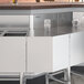 A Regency stainless steel 45-degree angle outside corner underbar filler on a counter in a professional kitchen.