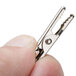 A hand holding an American Metalcraft double-sided metal sign clip.