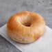 An Original New York Style Honey Wheat bagel on a white surface.