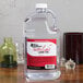 A clear jug of Sterno Soft Light liquid wax on a table.