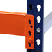 An orange Interlake Mecalux heavy-duty pallet rack beam with blue and orange metal pieces.