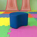 A blue Nicholas Moon modular ottoman on a colorful floor.