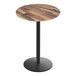 A Holland Bar Stool EuroSlim round wooden table with a black pole.