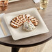 A World Centric compostable fiber plate with grilled chicken and potato salad on it.