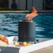 A Solo Stove tabletop fire pit burning on a tray of fruit on an outdoor table.