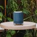 A blue Solo Stove Mesa tabletop fire pit on a round table.