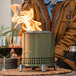 A person holding a glass of wine next to a Solo Stove Mesa XL tabletop fire pit.