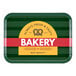 A green rectangular Cambro tray with a yellow and white bakery logo.