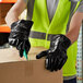 A person wearing a Showa black neoprene glove writing on a box.