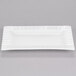 A white rectangular porcelain platter with a patterned design on the edge.