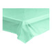 A mint green plastic tablecloth on a white table.