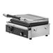 A Vollrath stainless steel panini grill with black and silver machine parts.