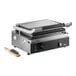 A single cast iron panini grill with smooth plates and a cleaning brush.