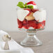 A glass of strawberry shortcake trifle made with Oregon Fruit In Hand Strawberry Filling on a white cloth.