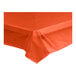 A Tangerine plastic table cover on a table.
