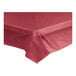 A burgundy plastic tablecloth on a table.