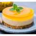 A cheesecake with orange passion fruit puree on top.