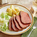 A plate of Unreal Deli plant-based corn'd beef with potatoes and cabbage.